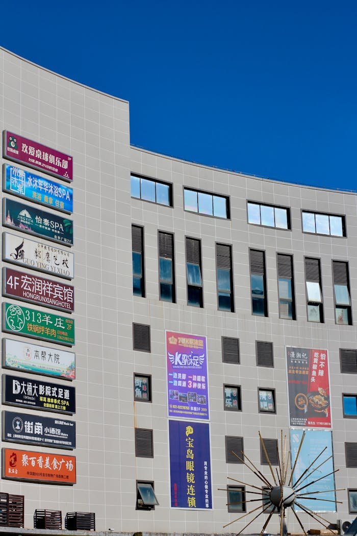 Exterior view of a commercial building featuring multiple colorful advertisement signs under a clear blue sky.